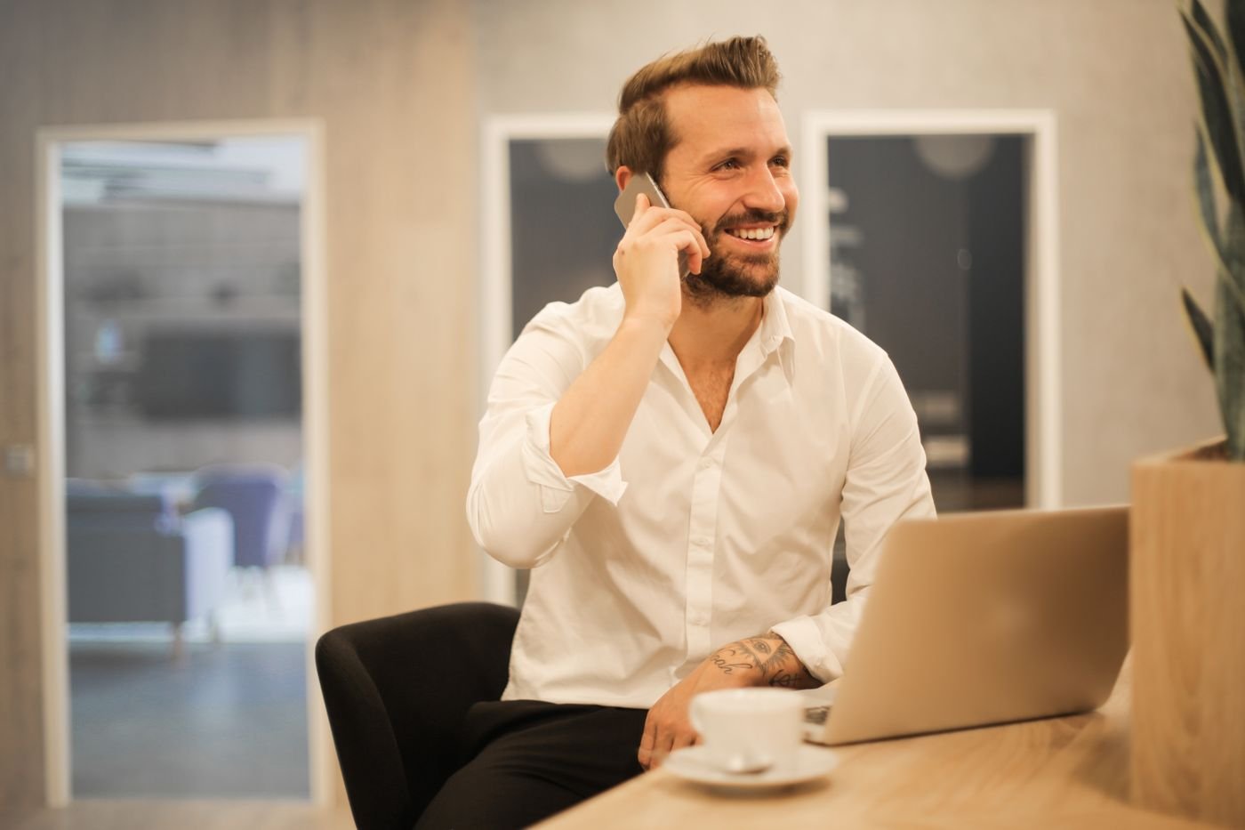 Empresario sonriendo mientras habla por teléfono en su oficina